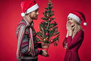 man och kvinna jul träd dekoration roligt Semester röd bakgrund foto