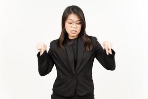 som visar produkt och pekande ner av skön asiatisk kvinna bär svart blazer isolerat på vit foto
