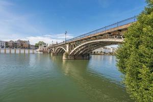 triana bro är en metall båge bro i sevilla Spanien den där ansluter de triana grannskap med de Centrum av de stad foto