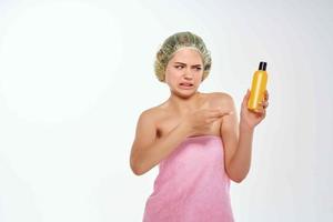 kvinna med olycklig ansiktsbehandling uttryck i rosa handduk lotion hud vård foto