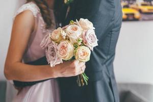 gift par som kramar och håller blommor foto