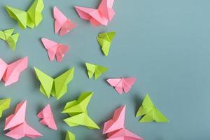 papper fjärilar grön och rosa Färg platt lägga på en färgad bakgrund. lätthet, vår skönhet begrepp foto