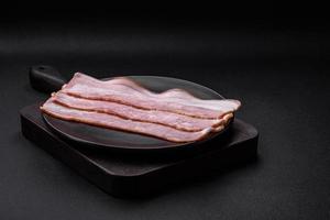utsökt färsk bacon Ränder med kryddor och salt foto