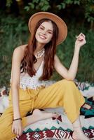skön ung flicka närbild utseende in i de kamera i en hatt bär ett eco hippie utomhus, skön leende med tänder i de solnedgång ljus foto