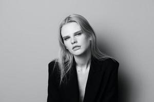 ung uttrycksfull skön blond professionell modell Framställ isolerat i studio klä på sig i svart jacka utseende på kamera. mode minimalistisk begrepp foto