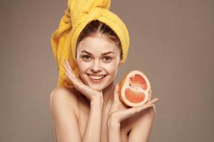 Söt kvinna bared axlar grapefrukt i hand naturlig kosmetika vitaminer foto