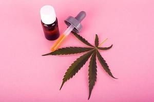 hampolja för medicinskt bruk, flaskor med medicinskt cannabisextrakt på rosa bakgrund