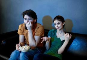 kväll TV tittar på och en gift par med popcorn i en tallrik foto