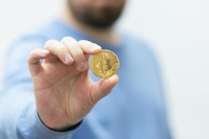 man som håller bitcoin i handen foto