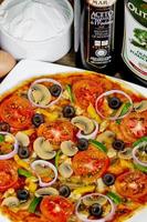 populär färgrik Ingredienser som tycka om tomater, ost, svamp, spansk peppar, oliver och Övrig Ingredienser bakad friska pizza. foto