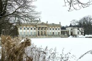 historisk palats på de vatten i lazienki krolewskie parkera i Warszawa, polen under snöig vinter- foto