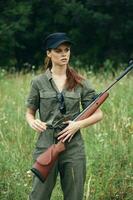 kvinna soldat vapen i hand utseende mot livsstil resa grön löv foto