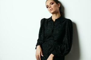 attraktiv brunett i svart klänning modern stil glamour studio foto