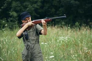 kvinna pistol i hand siktar jakt livsstil på utomhus- svart keps foto