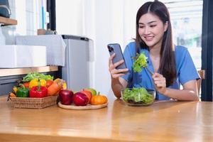 diet, ljushyad ung asiatisk kvinna i en blå skjorta äter vegetabiliska sallad och äpplen som en friska diet, välja för skräp mat. kvinna dietist förlorande vikt. friska äter begrepp. foto