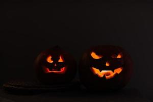 halloween pumpahuvudlykta på svart bakgrund. jack-o-lantern snidade pumpor för halloween. halloween pumpa med ögon som lyser inuti en svart bakgrund. idé för halloween foto