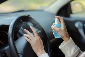 en kvinnas hand som sprutar alkohol, desinfektionsmedel i bilen, säkerhet, förhindrar infektion av covid 19-virus, koronavirus, kontaminering av bakterier eller bakterier. alkoholrenare, hygienkoncept