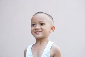 asiatisk pojke leende lyckligt rum vägg bakgrund foto