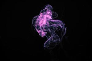lila rök på en svart bakgrund foto