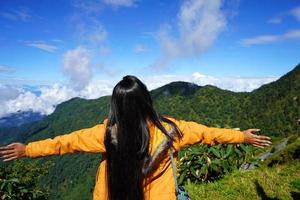 turist spridning henne hand mot de berg för känna de natur foto