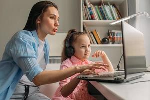 mamma som hjälper frustrerad dotter med online-skolan foto