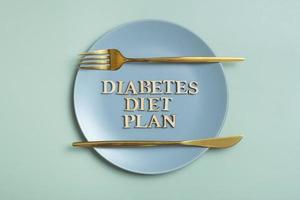 diabetes diet planen text på tallrik på färgad bakgrund med bestick platt lägga, topp se foto