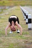 ung flicka håller på med yoga kondition övning morgon- soluppgång utomhus- i de äng skön bergen landskap. meditation och koppla av. foto