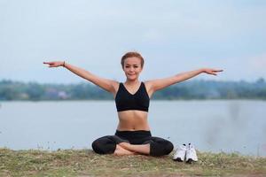 ung flicka håller på med yoga kondition övning morgon- soluppgång utomhus- i de äng skön bergen landskap. meditation och koppla av. foto