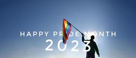 Lycklig stolthet 2023 på regnbåge flagga höjning i händer och blå himmel i de solnedgång bakgrund foto