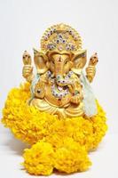 guld ganesha staty Gud är de herre av Framgång Gud av hinduism på ringblomma blommor isolerat på vit bakgrund. foto