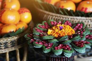 ringblomma och reste sig blommor i vas tillverkad av banan blad i traditionell thai konst dekorerad hantverk mönster i bröllop ceremoni traditionell. foto