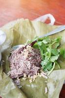 khao kan haka utsökt ris blandad med kokta fläsk blod med koriander på banan blad är tradition thai mat i nordlig av thailand. gata mat i marknadsföra foto