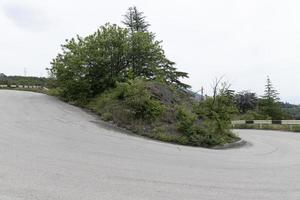 en brant berg böja av en asfalterad väg. bil resa. foto