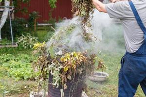 man bränning gräs i de trädgård foto