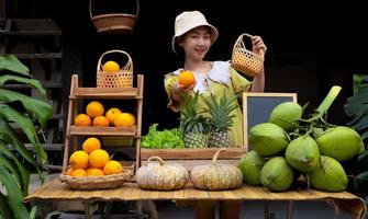 Asien kvinna försäljning en naturlig mängd av frukt på de bruka stanna kvar foto