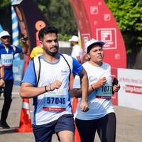 ny delhi, Indien - Mars 16 2023 - vedanta delhi halv maraton lopp efter covid i som maraton deltagarna handla om till korsa de Avsluta linje, delhi halv maraton 2022 foto