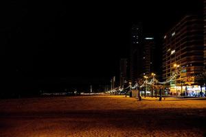 havet strand landskap med promenad på natt i Benidorm, Spanien foto