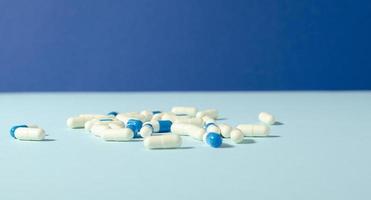 mediciner vit och blå kapslar på de blå bakgrund med kopia Plats. antibiotikum. apotek mall. farmaceutisk läkemedel. foto
