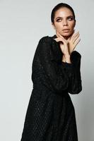 Söt brunett sida blick svart klänning glamour mode foto