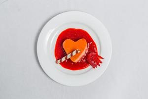 hjärta formad pudding med jordgubb sås och rån. valentines efterrätt recept. foto