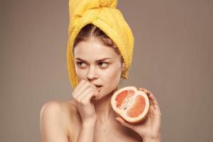 Söt kvinna grapefrukt i hand rena hud vitaminer hälsa foto