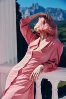 Söt kvinna i en rosa klänning utomhus natur se avslappning begrepp foto