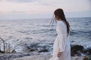 kvinna i vit klänning Framställ hav resa sommar oförändrad foto