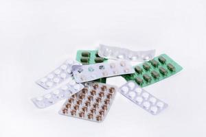 plattor med piller från annorlunda medicinsk läkemedel lögn i en lugg på en vit bakgrund foto