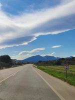 lugna landskap av Spanien med en se av de pyreneerna på de horisont och ett tömma väg foto