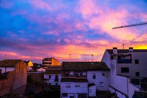 himmel bakgrund med moln efter solnedgång över mörk hustak foto