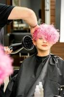 frisör torkning rosa hår av klient foto