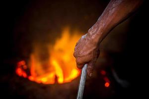 osäker arbetstagare händer. en lokal- stål maskin delar framställning gård arbetstagare smältande skrot på varm ugn. foto