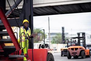 ingenjör man arbetstagare i säkerhet overall enhetlig med gul Hardhat och använda sig av bärbar dator dator kontrollera på frakt behållare fartyg hamn lager.transport import Export logistisk industriell service foto