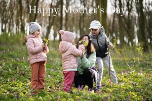 Lycklig mors dag. vi kärlek du, mamma. mor med en bukett av blommor och tre barn i vår blomning skog. foto